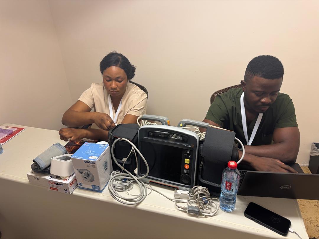 Clinicians preparing monitoring and vital-signs equipment before delegates arrive.